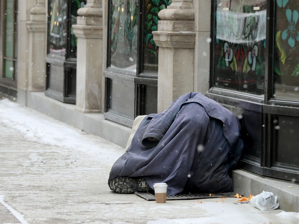  a homeless person tries to keep warm on sparks street.