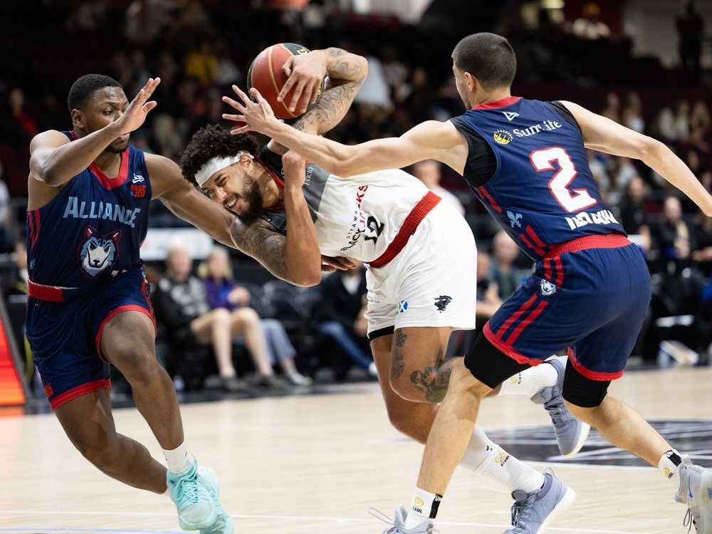  The Ottawa Blackjacks’ Tyrrel Tate, centre, gets squeezed between Montreal Alliance’s Alain Louis, left, and Freddy Ibrahim during CEBL basketball action in Ottawa in June 2024.