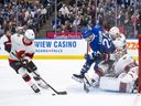 Senators centre Tim Stutzle (18) clears the puck as Maple Leafs forward Scott Laughton (24) and Ottawa teammate Thomas Chabot (72) collide with goaltender Linus Ullmark in the second period.
