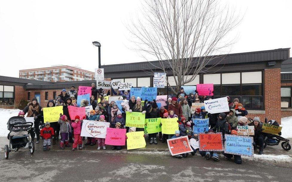  parents and their children gathered in protest in front of woodroffe avenue public school on monday. parents were shocked and outraged when new boundaries for elementary schools were released friday.