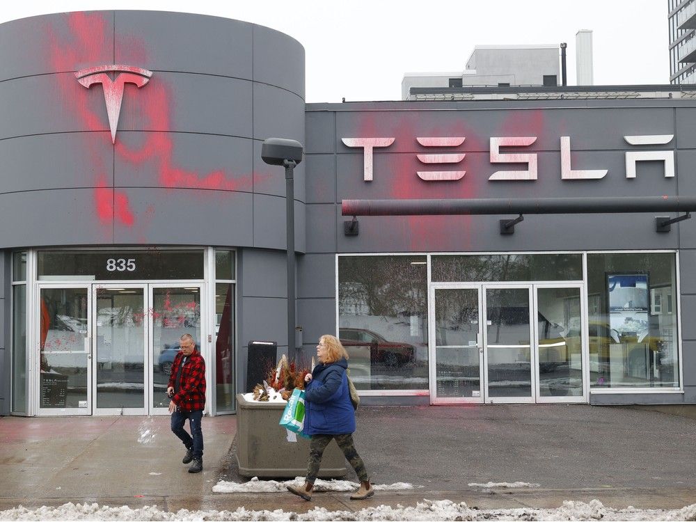 one protestor was arrested after a tesla dealership on carling avenue was spray painted with red paint.