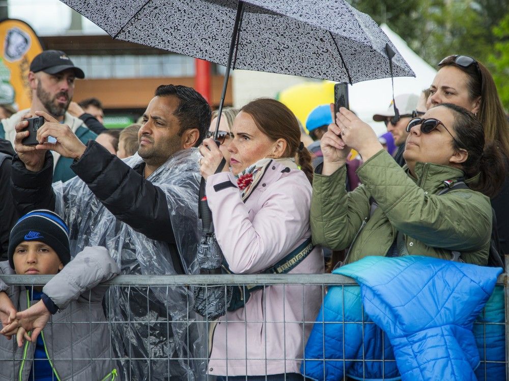  Parents line the race route to snap pictures of participants in the Kids Marathon on Saturday afternoon.