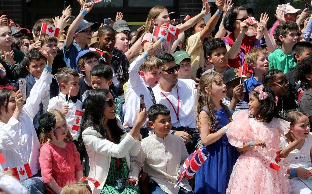  A group of kids screamed for the King and Queen as they passed by.