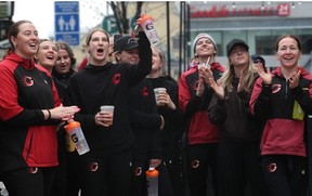 Members of the Ottawa Charge cheer as a Charge Avenue sign is put up