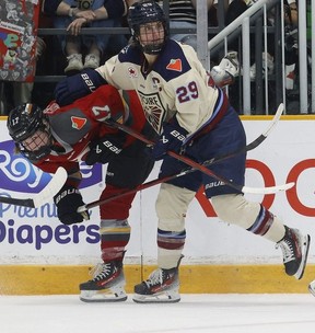 Gabbie Hughes of the Ottawa Charge works the boards with Marie-Philip Poulin of the Montréal Victoire during second-period action at TD Place in Ottawa on Friday.