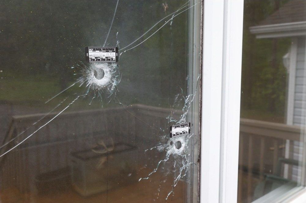  Three gunshot holes, two in the front window and one in the siding, were visible from the outside of the home.