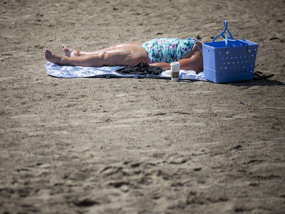  A woman was soaking in the hot sun at Westboro beach Sunday morning. The scent of sunscreen lingered in the air as a welcome breeze drifted in from the Ottawa River, offering brief relief from the sweltering heat that blanketed Ottawa under a heat warning on Sunday, June 22, 2025.