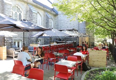 Red chairs on a shaded patio next to a repurposed church