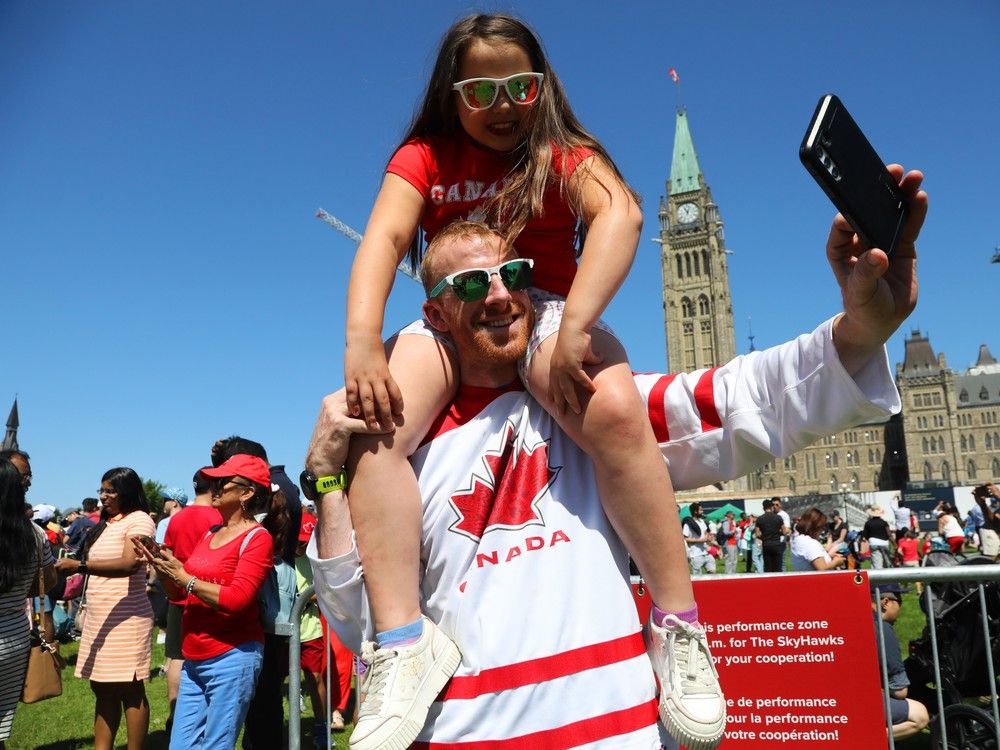  Seamus McConnell holds up his nine year old daughter Callie McConnell while taking a selfie on Parliament Hill during Canada Day festivities in Ottawa, July 01, 2024.