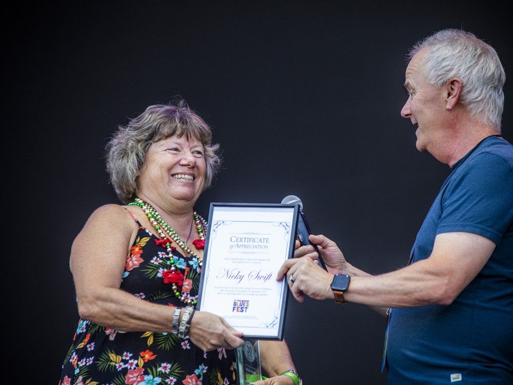  OTTAWA –Ottawa Bluesfest executive director, Mark Monahan, recognized Nicky Swift on the RBC Stage for her 30 years of volunteer work, Saturday, July 13, 2024. Swift was presented an award and a lifetime pass to the festival.Ashley Fraser/Postmedia