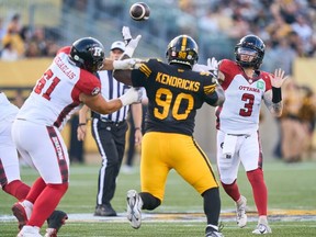 Ottawa Redblacks quarterback Dru Brown throws a pass under pressure by the Hamilton Tiger-Cats' Mario Kendricks