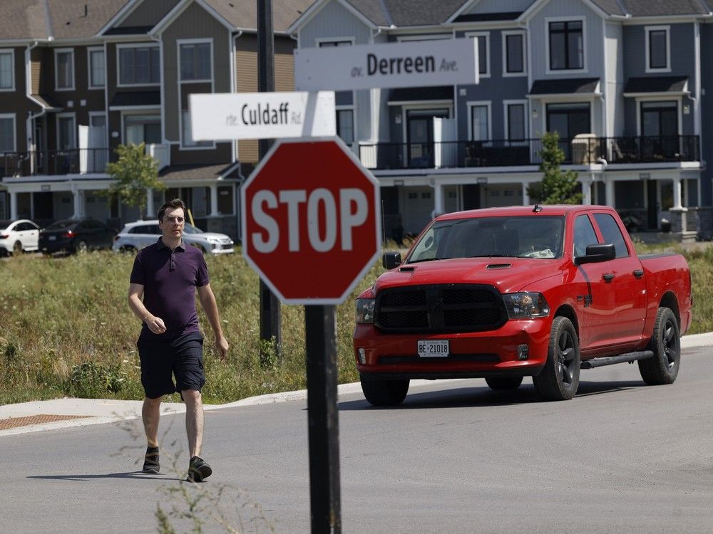  Tyler Sommers crosses the street at the intersection of Derreen Avenue and Culdaff Road in Stittsville. Residents of a new Stittsville development are worried about the removal of a four-way stop, the only place along the busy street that pedestrians can legally cross.