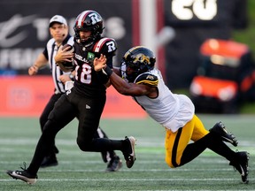 Dustin Crum (18) is sacked by Hamilton Tiger-Cats defensive lineman TyJuan Garbutt