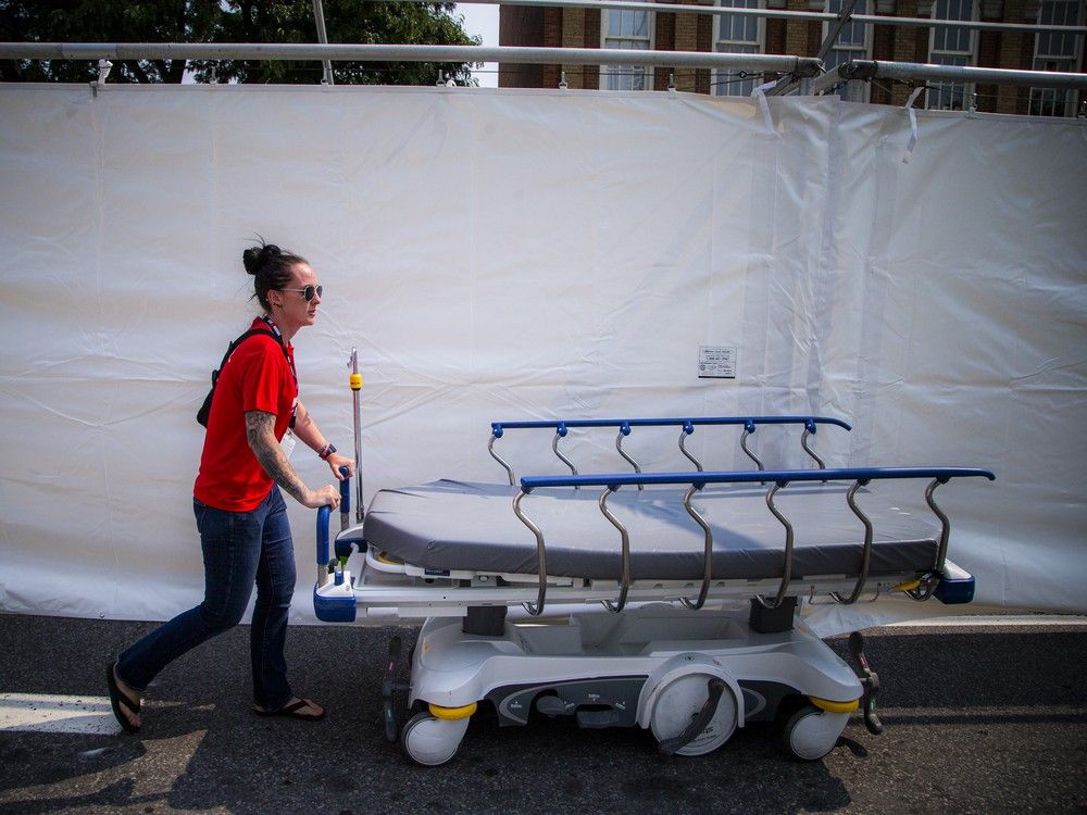 The Ottawa Hospital set up a satellite clinic on a closed section of Sussex Drive for Sunday’s Ironman triathlon, led by medical team lead Karen Lawrence and staffed by a team of health-care professionals. Laura Gauvreau, critical care lead, pushes a bed through the tent to one of the rooms that have been built in the tent.