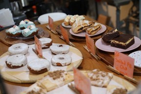 An array of baked goods on a wooden counter, from donuts to nanaimo bars