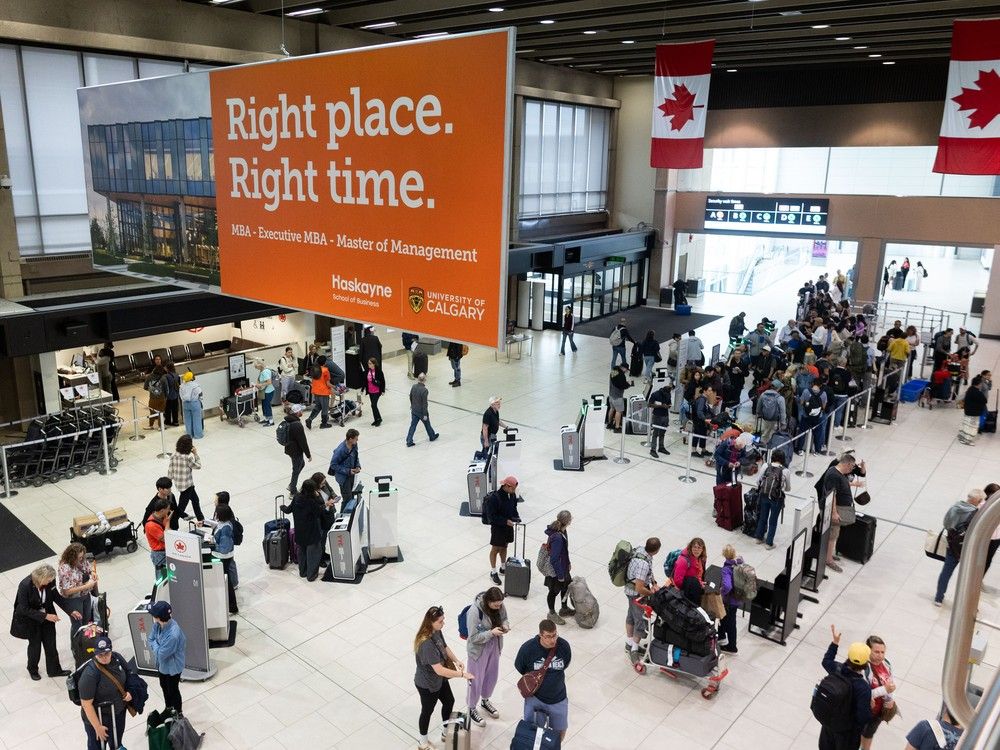 Air Canada passengers amass at the check in counters of Calgary International Airport on Friday, August 15, 2025 following the airline's choice cancel flights in anticipation of a strike.