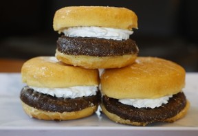 Three donuts cut in half and filled with cream to look like hamburgers stackes