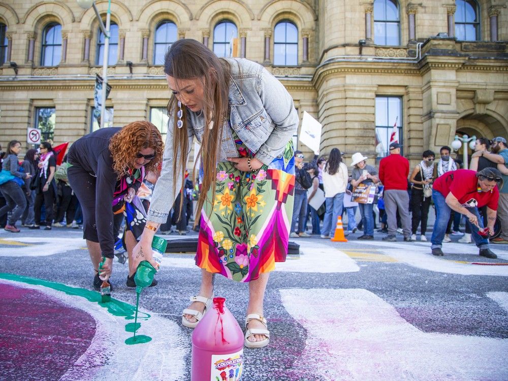  Wellington Street was painted with the words “People Peace Planet – Not Profit,” which remained closed Saturday afternoon for cleanup.