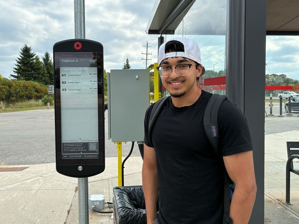  Commuter Uzair Ahmed says he’s not sure if he can trust OC Transpo’s new transit information screen, which shows different bus times from the Google Maps route he usually uses to track his trip. He’s seen here in front of the Eagleson Park & Ride bus information screen, which is one of four installed around the city as part of a year-long pilot project.