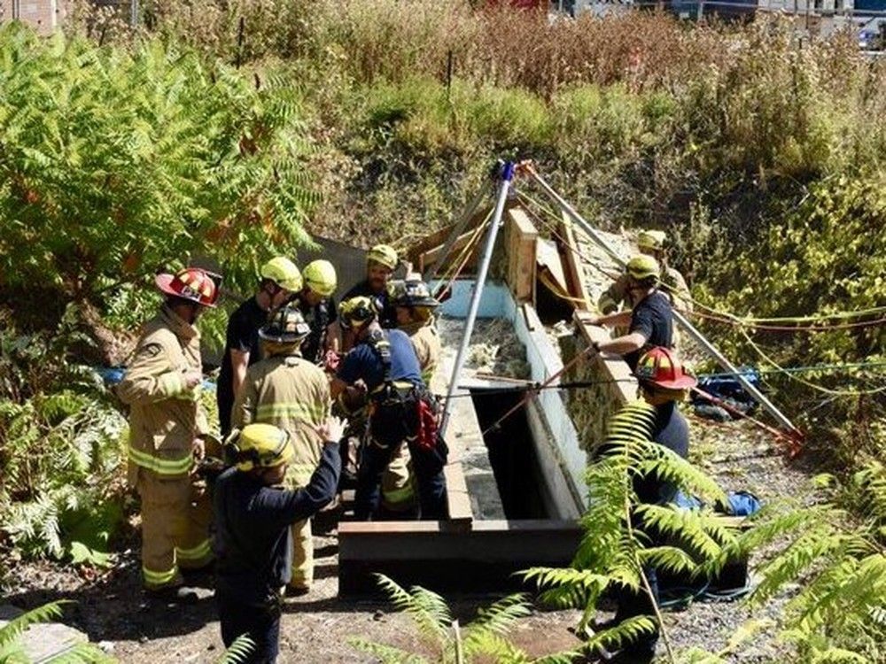  Emergency workers team up to rescue worker trapped in hole.