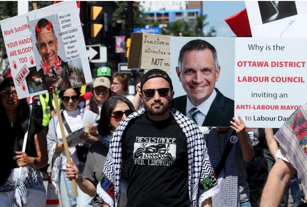  A vocal pro-Palestinian contingent was part of the march, holding up signs denouncing Ottawa Mayor Mark Sutcliffe, who was at the front of the procession, leading it with the Ottawa and District Labour Council.