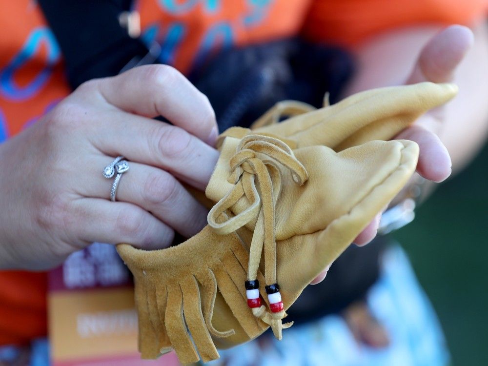  Marsha Wabie, from Timiskaming First Nation in Quebec, quietly dropped a tiny pair of moccasins with the other shoes at the front of the stage to mark the missing residential school children.