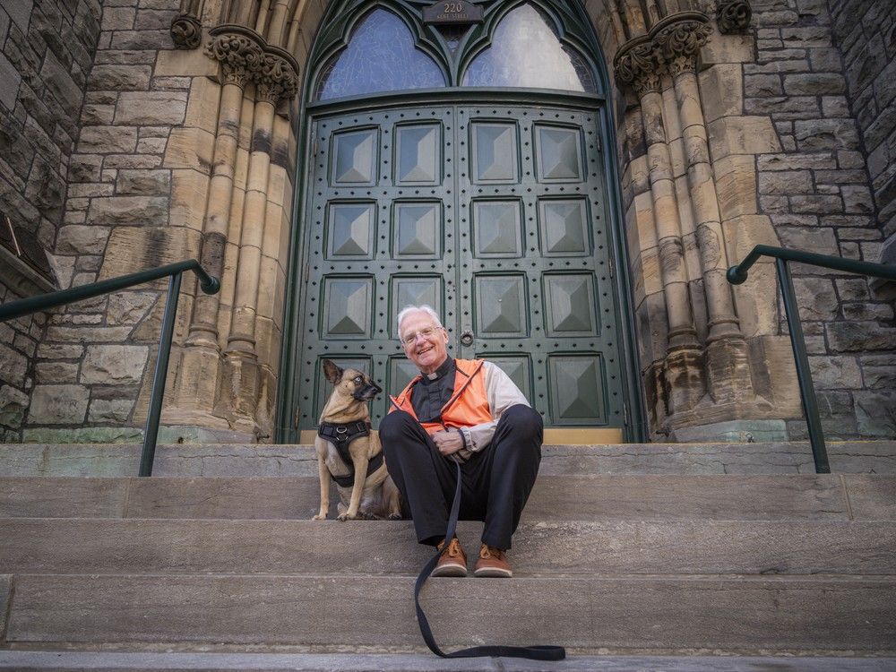 Father Amesse sits on the front step of the downtown Ottawa church with his dog Joey.  Father Amesse sits on the front step of the downtown Ottawa church with his dog Joey.