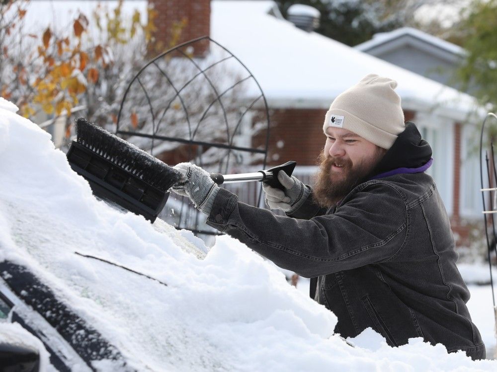  Patrick Souter clears snow from his car Monday.