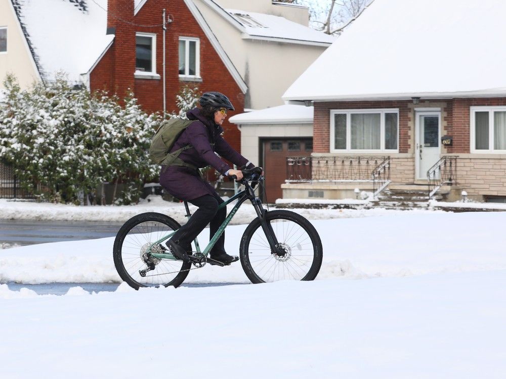  A cyclist braved snow on the bike path Monday along Richmond Road as the City of Ottawa received its first snowfall of the season.