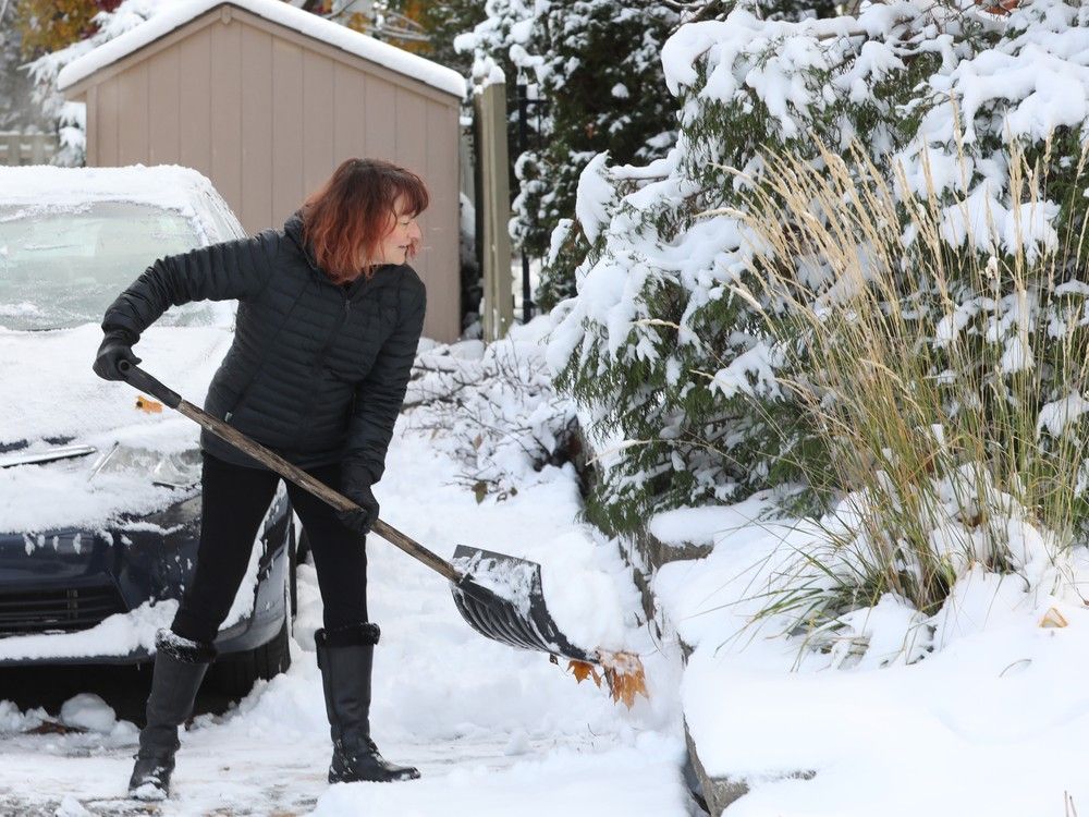  Jenn Brennan shovels her driveway Monday.