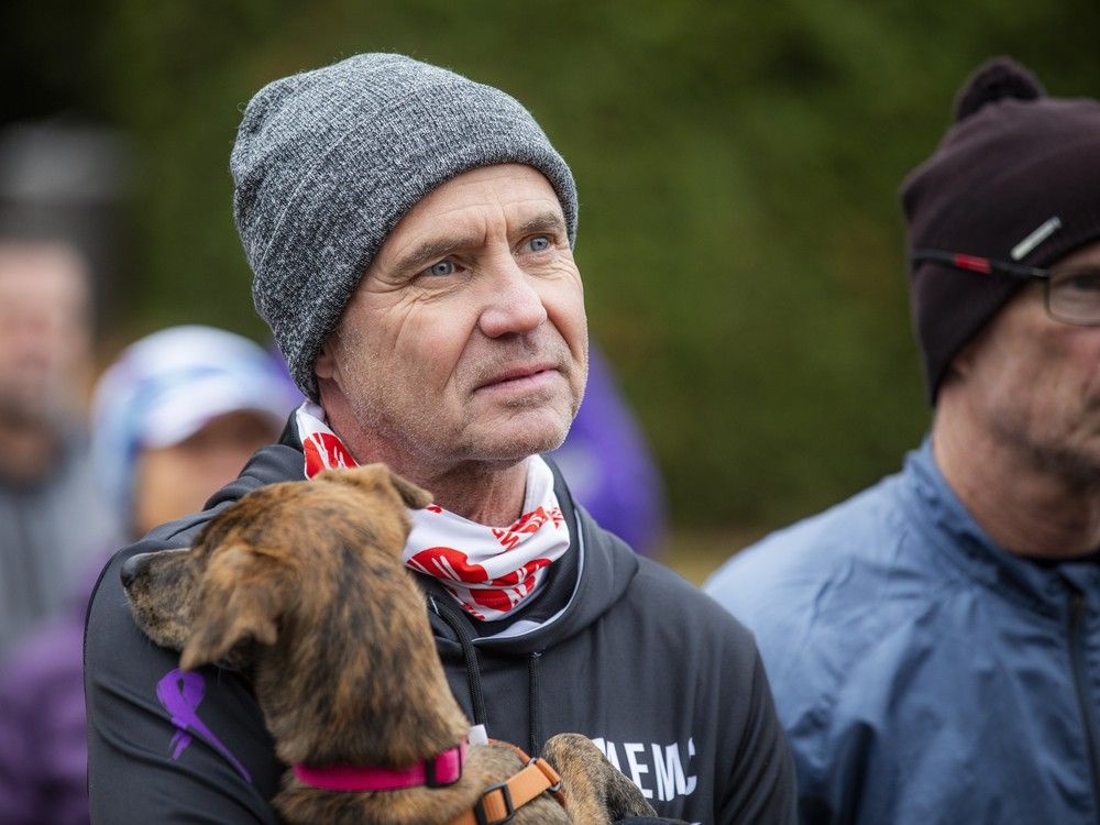  Ian Fraser, a well-known member of Ottawa’s running community and a close friend of Sindy Hooper, listens to the speeches while holding his puppy, Piper.