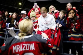 Katerina Mrazova of the Ottawa Charge signs an autograph for an excited young fan before the PWHL team's first game of the 2025-26 regular season against the New York Sirens at Ottawa on Saturday.
