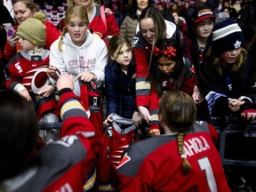 Ottawa Charge backup goaltender Sanni Ahhola (1) and a teammate sign autographs for young fans before the PWHL team's first game of the 2025-26 regular season against the New York Sirens at Ottawa on Saturday.