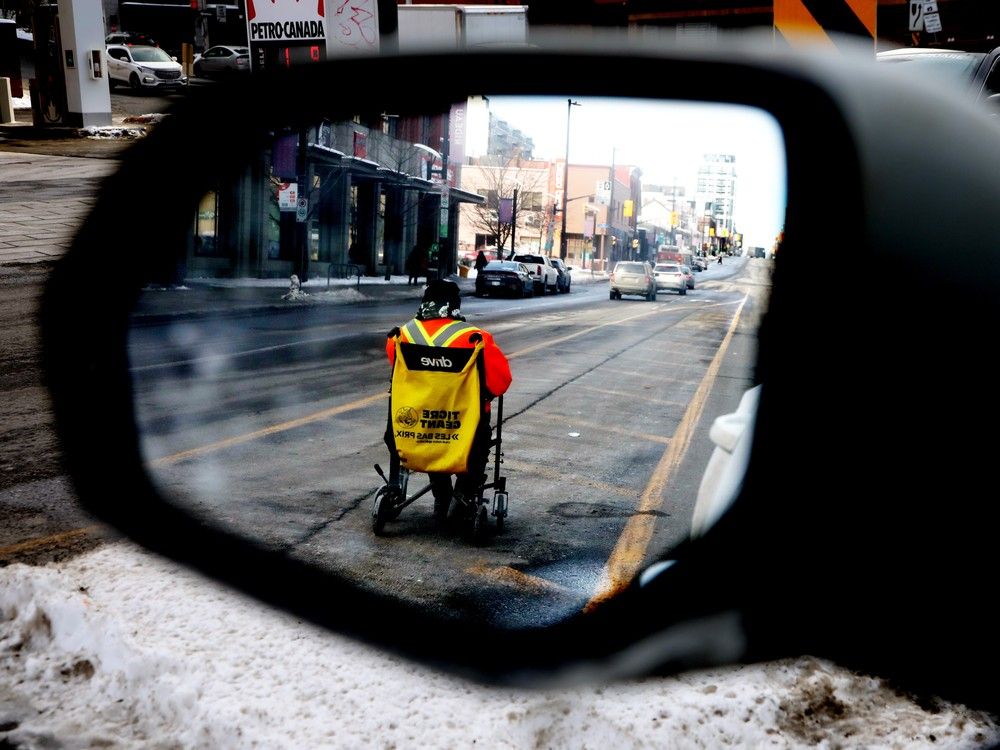 A man seeks money donations at the intersection of Rideau Street and King Edward Avenue in Ottawa, Feb. 11, 2025.