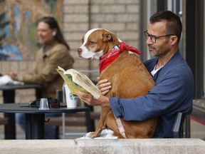 OTTAWA - Oct 8, 2025 -- Chris Bickford and his dog Lily-Loo read and have coffee on Bank Street.