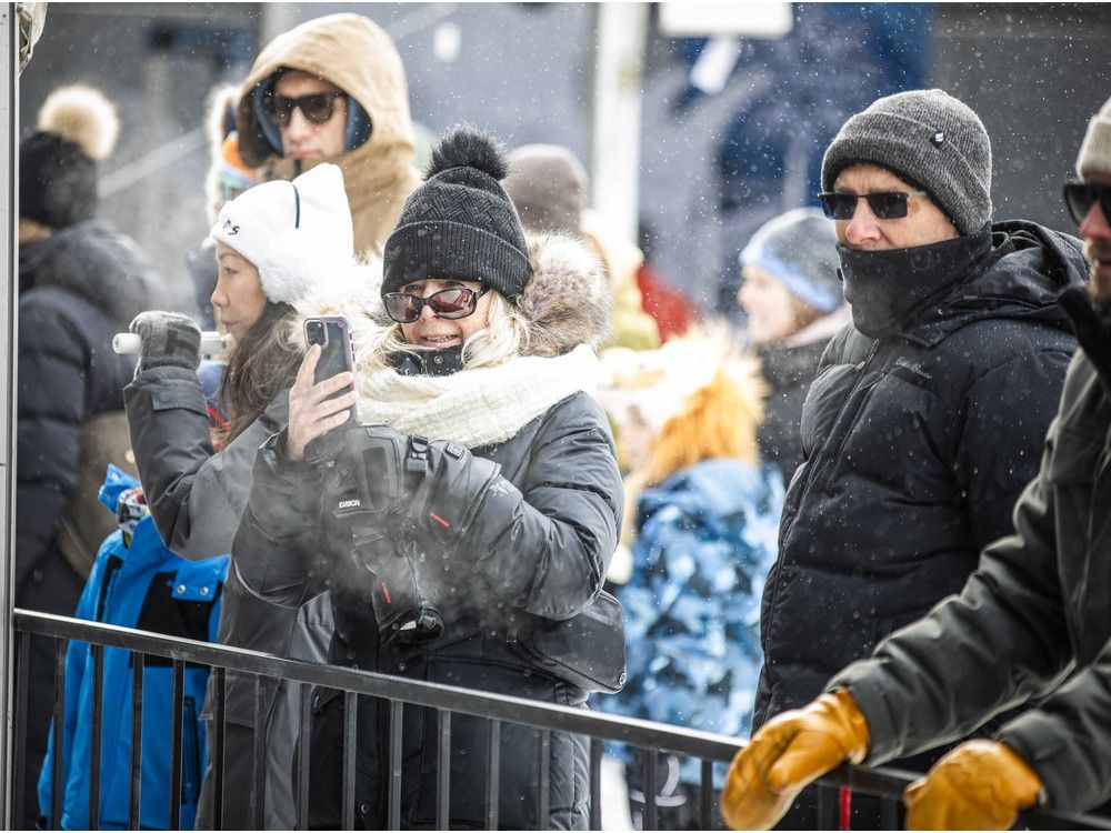  People gathered at a safe distance to watch ice carvers transform massive blocks of ice into spectacular works of art, stopping to admire the skill and detail taking shape before them.