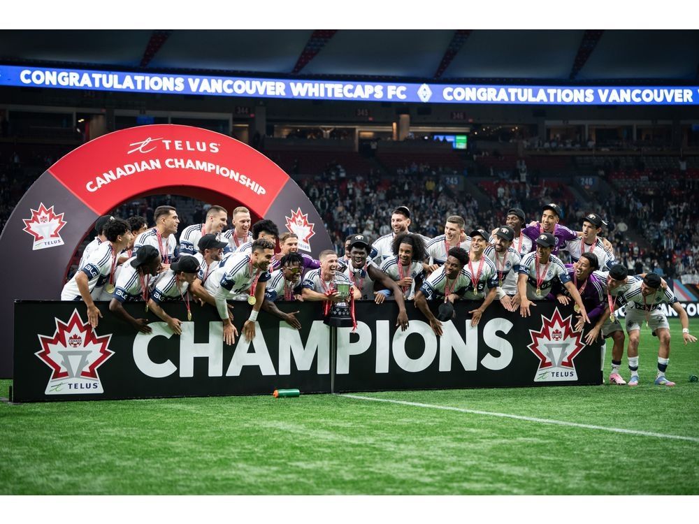 Vancouver Whitecaps' Ryan Gauld, centre, prepares to hoist the Voyageurs Cup with his team after defeating Vancouver FC in the Canadian Championship final soccer match in Vancouver, on Wednesday, Oct. 1, 2025.