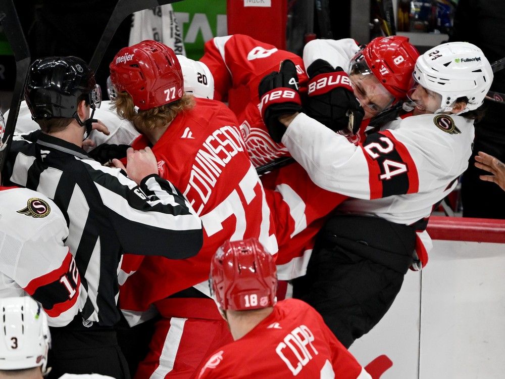 Ottawa Senators centre Dylan Cozens grabs Detroit Red Wings defenceman Ben Chiarot
