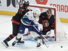 Vancouver Canucks centre Aatu Raty tries to tip the puck past Ottawa Senators goaltender Leevi Merilainen