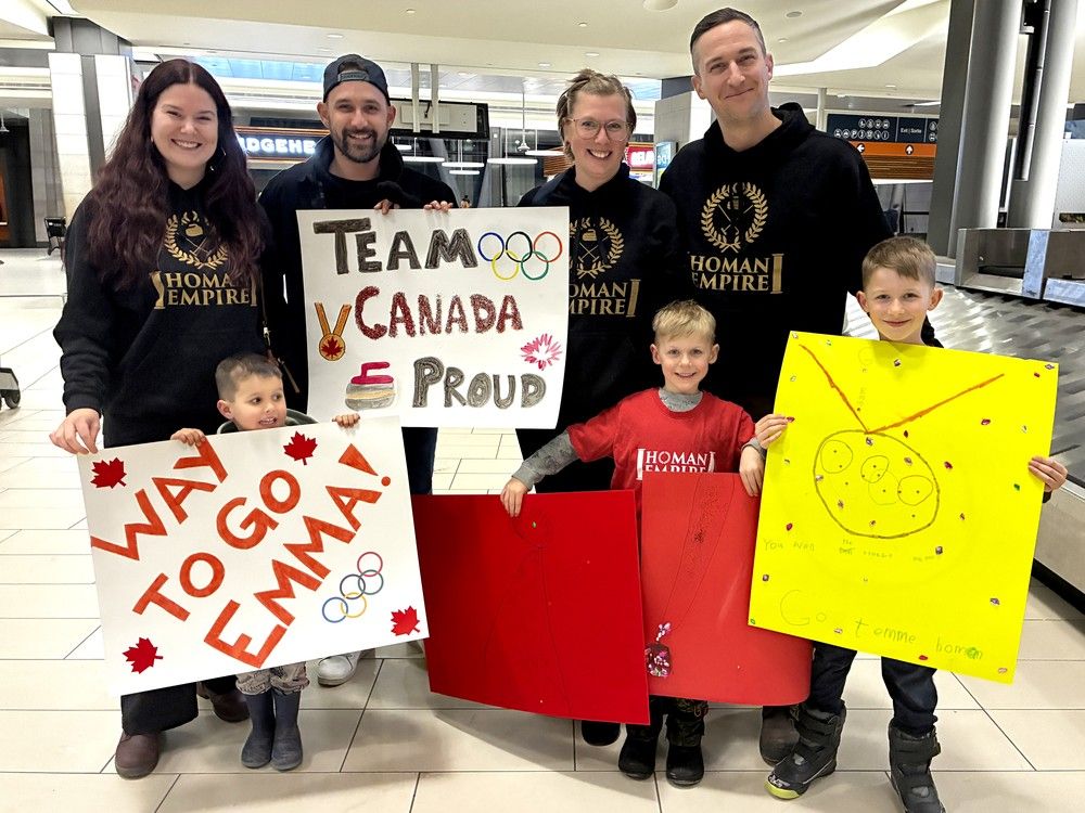  Curling fans at the Ottawa/Macdonald&ndash;Cartier International Airport on Monday night to greet bronze-medallist Emma Miskew upon her return from the Milano-Cortina Winter Olympics. Front row: Cayden Chennette, Aeden Charron, Caleb Charron. Back row: Natalie and Andrew Chennette, Courtney and Jeremie Charron.