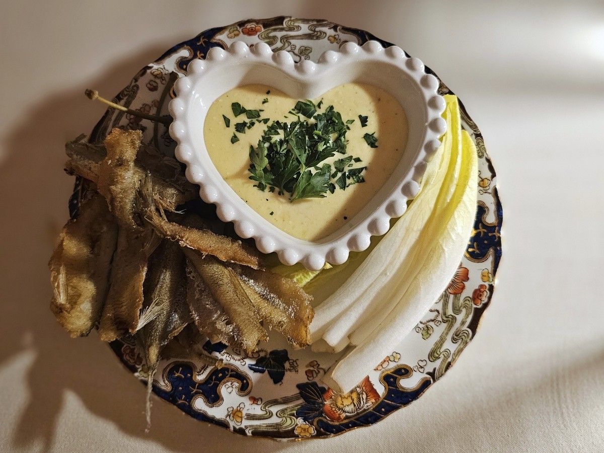  Fried smelt served with endive leaves meant to be used as a shell and lemon parmesan aioli for dipping.