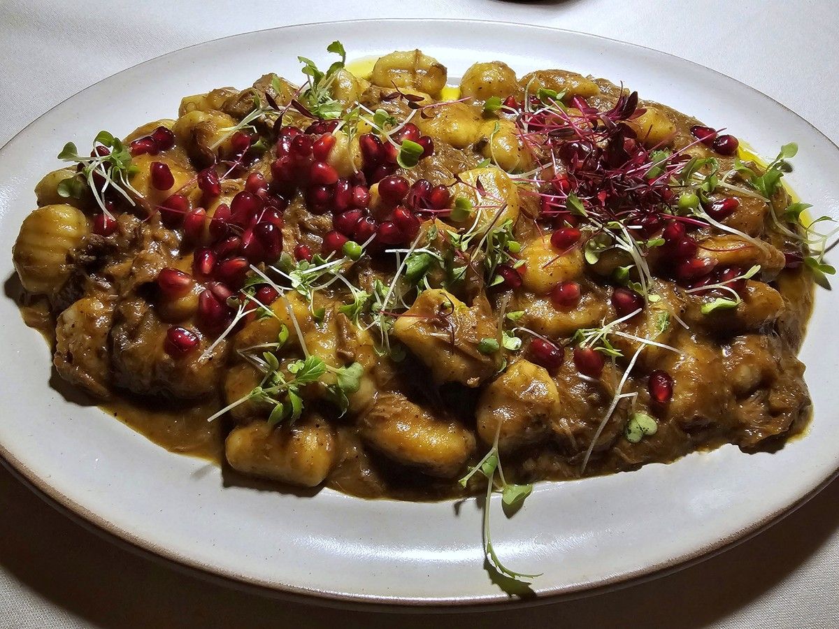  Gnocchi in a slow-braised lamb rag&ugrave;, scattered with pomegranate seeds.
