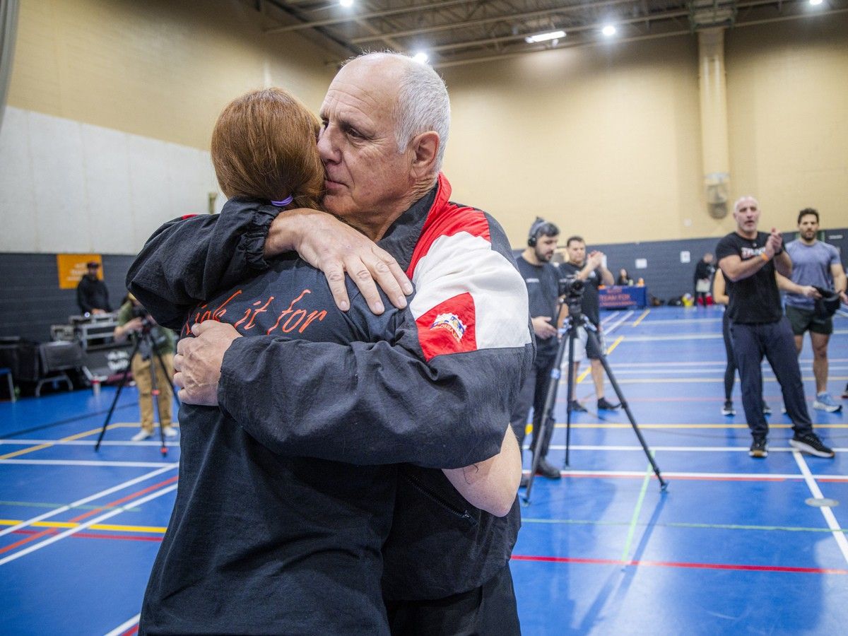  Jean-Yves “The Iceman” Theriault, a former world kickboxing champion, and Chantal Theriault’s father, gives her a hug during the Kick It for Parkinson event on Saturday.