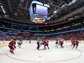 Hockey players line up for a faceoff.