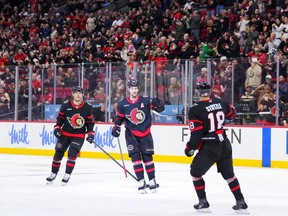 Thomas Chabot of the Ottawa Senators celebrates his second period goal against the Anaheim Ducks with Shane Pinto #12 and Tim Stützle.