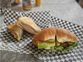 Two sandwiches on checkered black and white paper