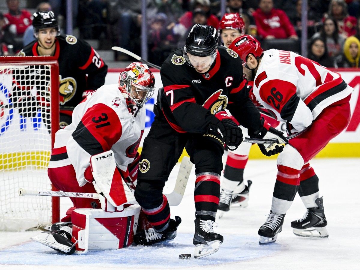  The Ottawa Senators&rsquo; Brady Tkachuk tries to the play the puck off his skate in front of Carolina Hurricanes goaltender Frederik Andersen.