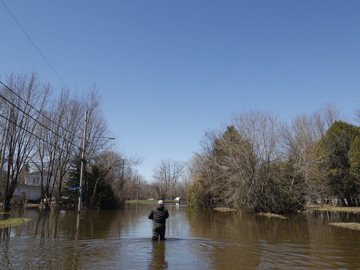  A man walks back to his house through the water near Rue Ernest-Charron in Gatineau Monday.