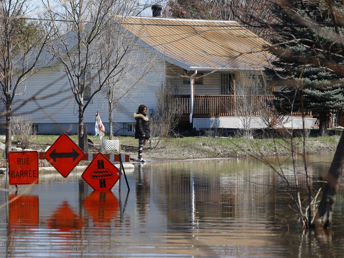  A woman watches the rising water on Rue Saint-Louis in Gatineau Monday.