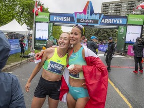 Jade Berube and Elissa Legault celebrate after crossing the finish line at the Tamarack Homes Ottawa International Marathon on Sunday morning.